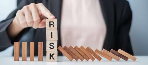 Businesswoman hand Stopping Falling wooden Blocks or Dominoes.